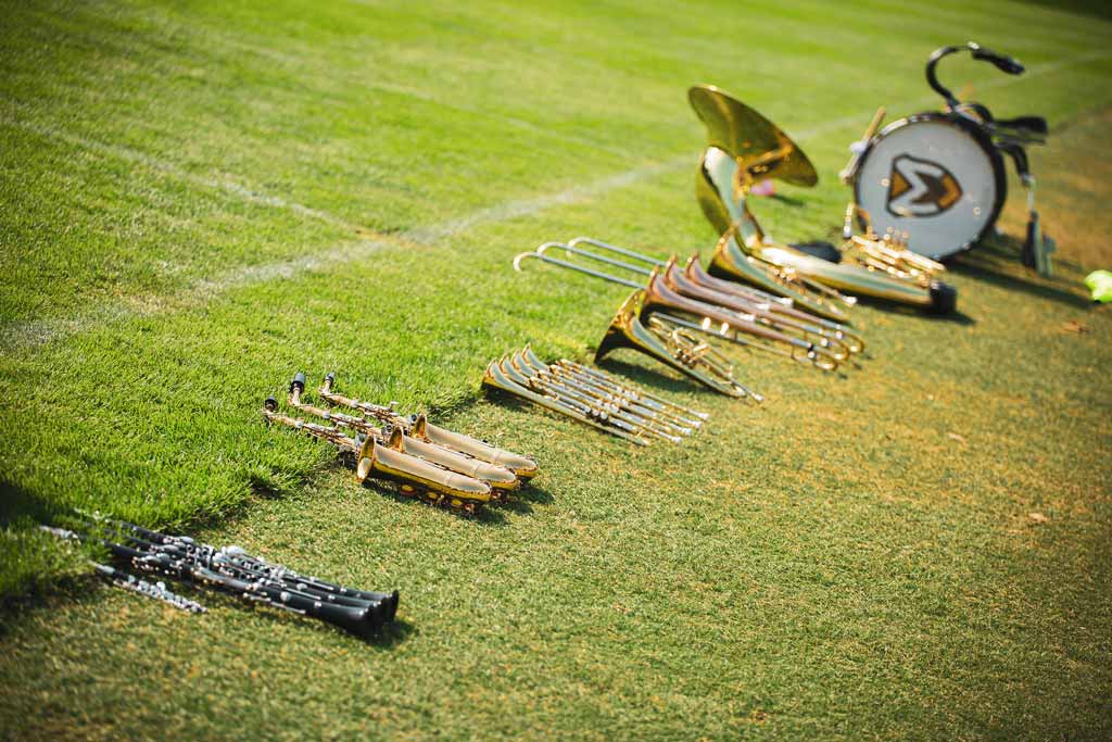 Marching band instruments stacked on the sideline