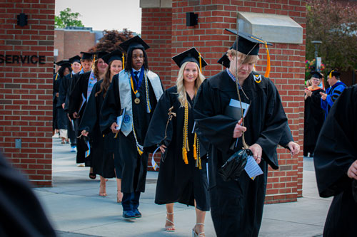 Graduating students walking under the chime tower