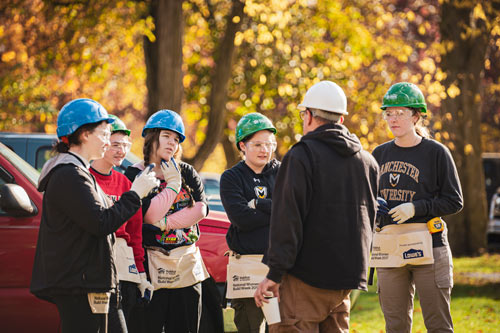 A group of honors students doing volunteer work for habitat for humanity