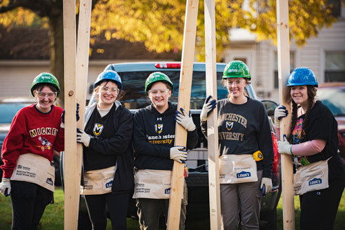 A group of honors students doing volunteer work for habitat for humanity