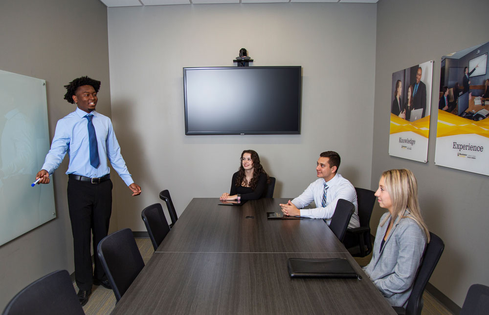 Students practice a mock presentation during a marketing course.