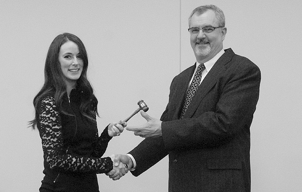 Alexis Young passes the Chamber gavel to Chris Garber in January 2015.
